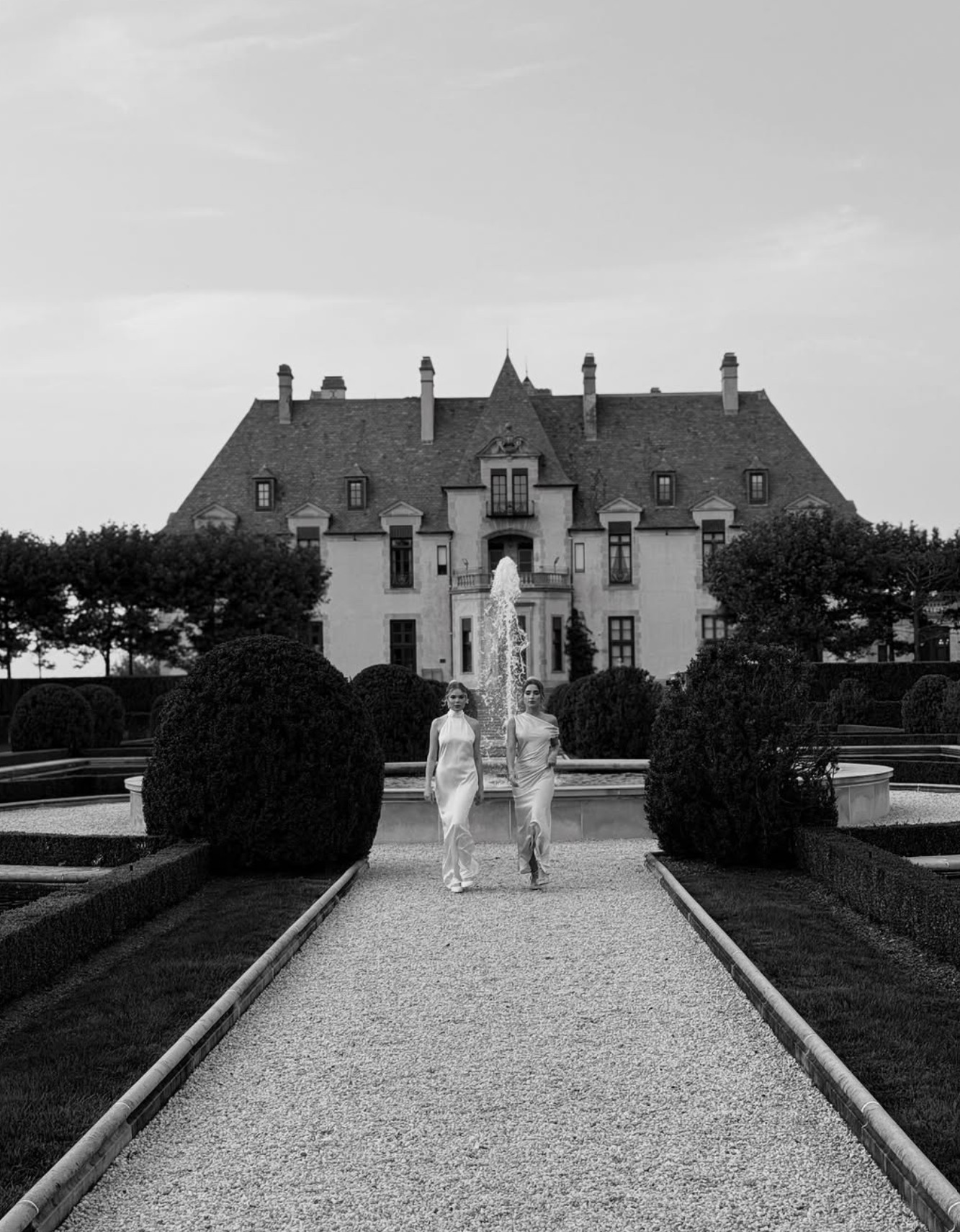 Newlyweds sharing a quiet moment in a lush garden, black and white